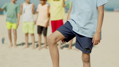 Vertikale-Bewegung-Eines-Lächelnden-Jungen,-Der-Einen-Fußball-Vom-Boden-Hebt